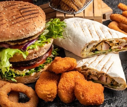 Fastfood Kültürünün Yükselişi ve Etkileri Dünya genelinde hızla yaygınlaşan fastfood kültürü, modern yaşam tarzının en dikkat çeken alışkanlıklarından biri haline geldi. Özellikle 20. yüzyılın ikinci yarısından itibaren Amerika’da doğup tüm dünyaya yayılan bu kültür, kısa sürede milyonlarca insanın günlük hayatına yerleşti. Hızlı, pratik ve görece ucuz olması nedeniyle tercih edilen fastfood, insanların yoğun iş temposu ve zaman sıkıntısı yaşadığı modern şehir yaşamında büyük bir kolaylık sağladı. Konulu bir haber görseli.